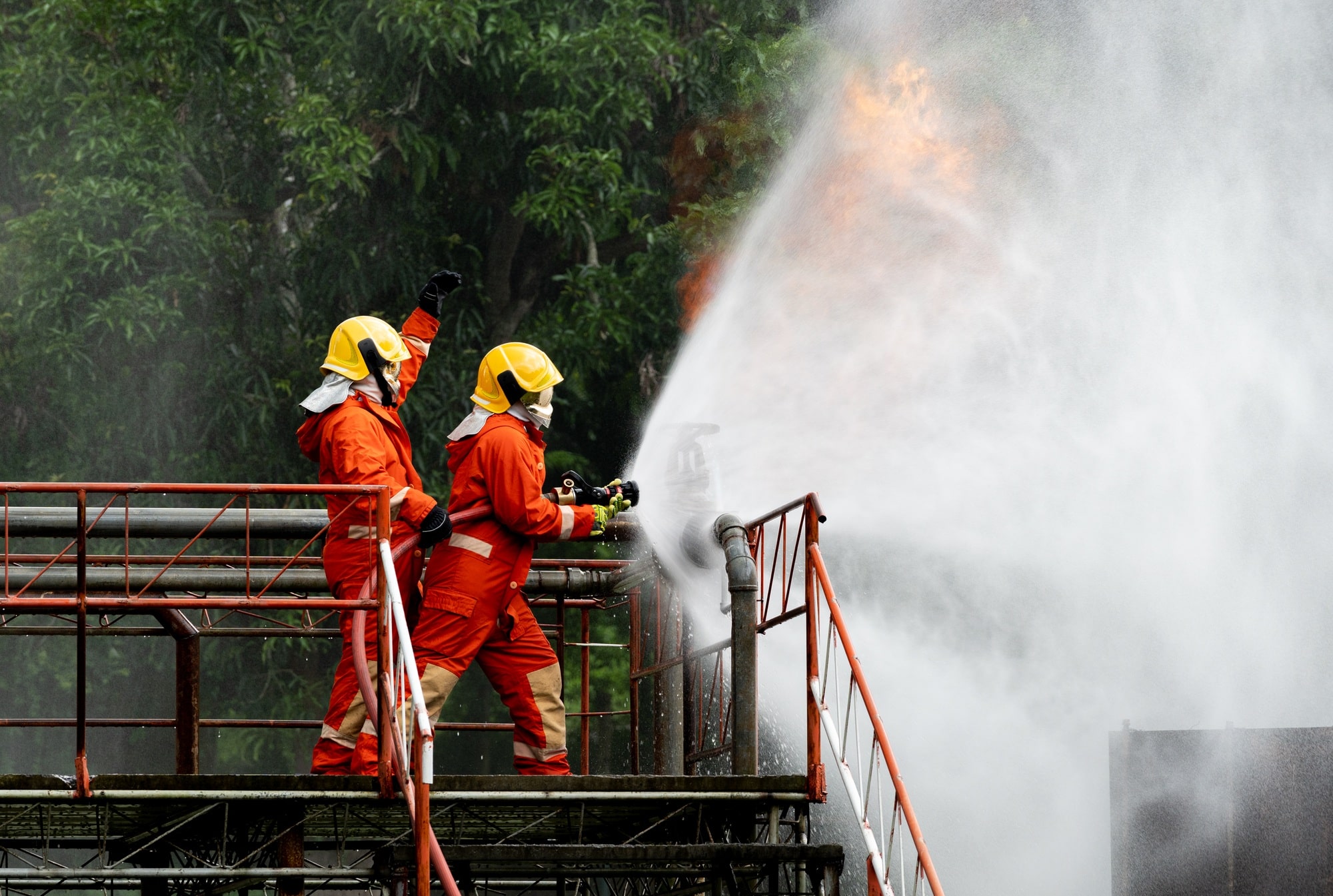 Firefighters or Firemen use extinguisher and spray high pressure water from hose to control fire